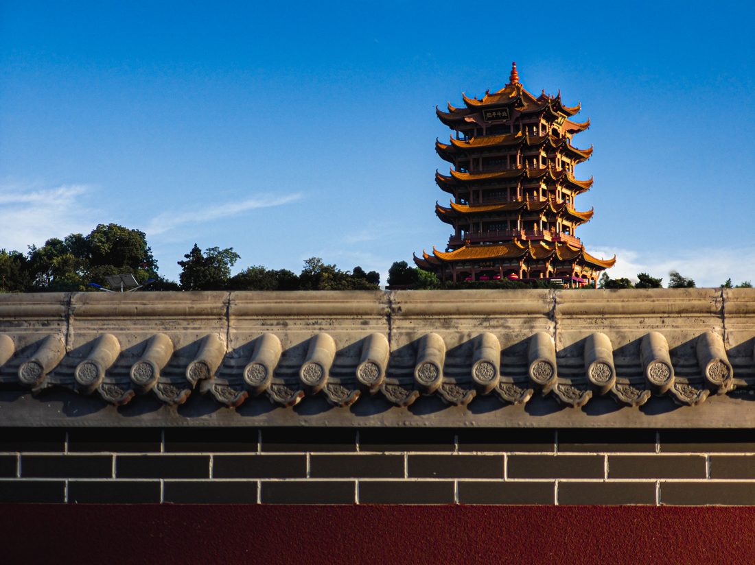 晴空下的古塔从屋脊后方显露出来。